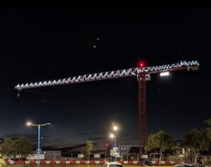 A crane on Scarborough Hospital's building site. It's night time and the crane is covered in lights.