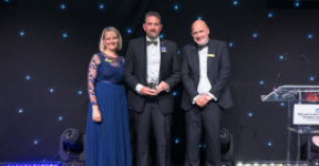 Rich Atkinson onstage with Dawn Parkes, Chief Nurse, and Simon Morritt, Chief Executive. All three are wearing formal clothing.