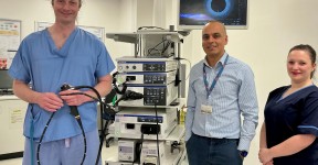 Colleagues alongside a large piece of healthcare equipment.