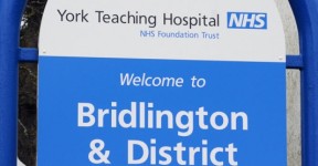 A blue and white hospital sign with white text.