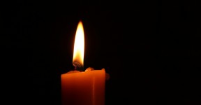 A single candle flame in a dark room.