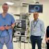 Colleagues alongside a large piece of healthcare equipment.