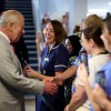 His Majest King Charles shaking hands with a member of the public while surrounded by other healthcare professionals.