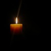 A single lit candle glowing in darkness.