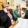 Two female receptionists on the phone at a desk smiling