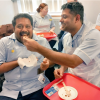 Two staff members eating cake.