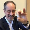 Professor James Turvill sitting in his office is pictured holding a 'Colocap' up to the camera.