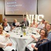 Staff sitting together around a table at a Long Service event.