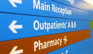Internal hospital signage with arrows to Main Reception, Outpatients and Pharmacy