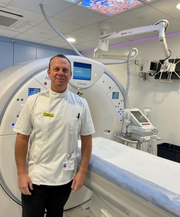 Darren standing alongside a CT machine.