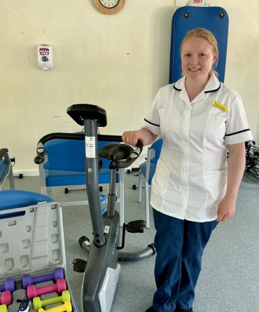 Dr Frances Butler in a physiotherapy room, surrounded by physiotherapy equipment.