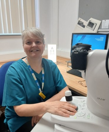 Jo sitting behind a piece of eye screening equipment.