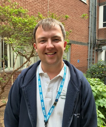 Head and shoulders shot of Alex in the courtyard at York Hospital.