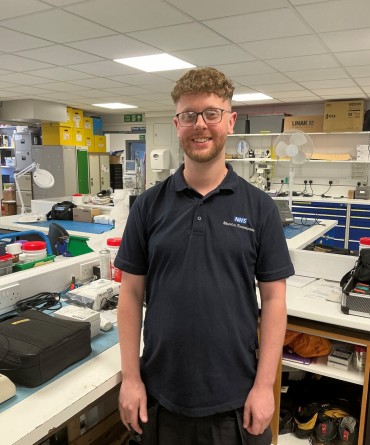 Ben in a workshop, surrounding by engineering equipment.