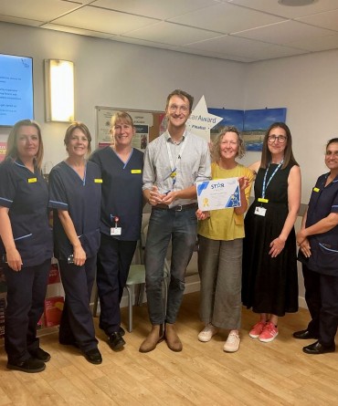 Star Award winner Michal Sladkowski receiving his award from Clare Smith, Chief Executive, and his nominators, the Breast Care Nursing Team.