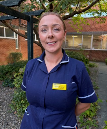 Jessica in her navy sisters' uniform, standing in a hospital courtyard.
