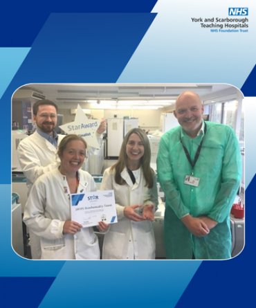 A group of people posing for a photo in a hospital laboratory.