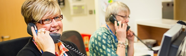 Two receptionists on the phone in an office