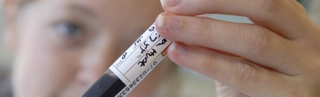 A scientist holding up a blood sample