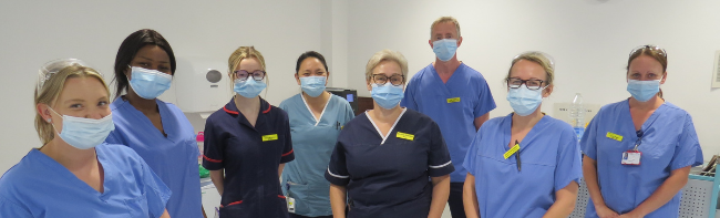 Many endoscopy staff in blue nursing uniforms and blue scrubs lined up in a patient rest room