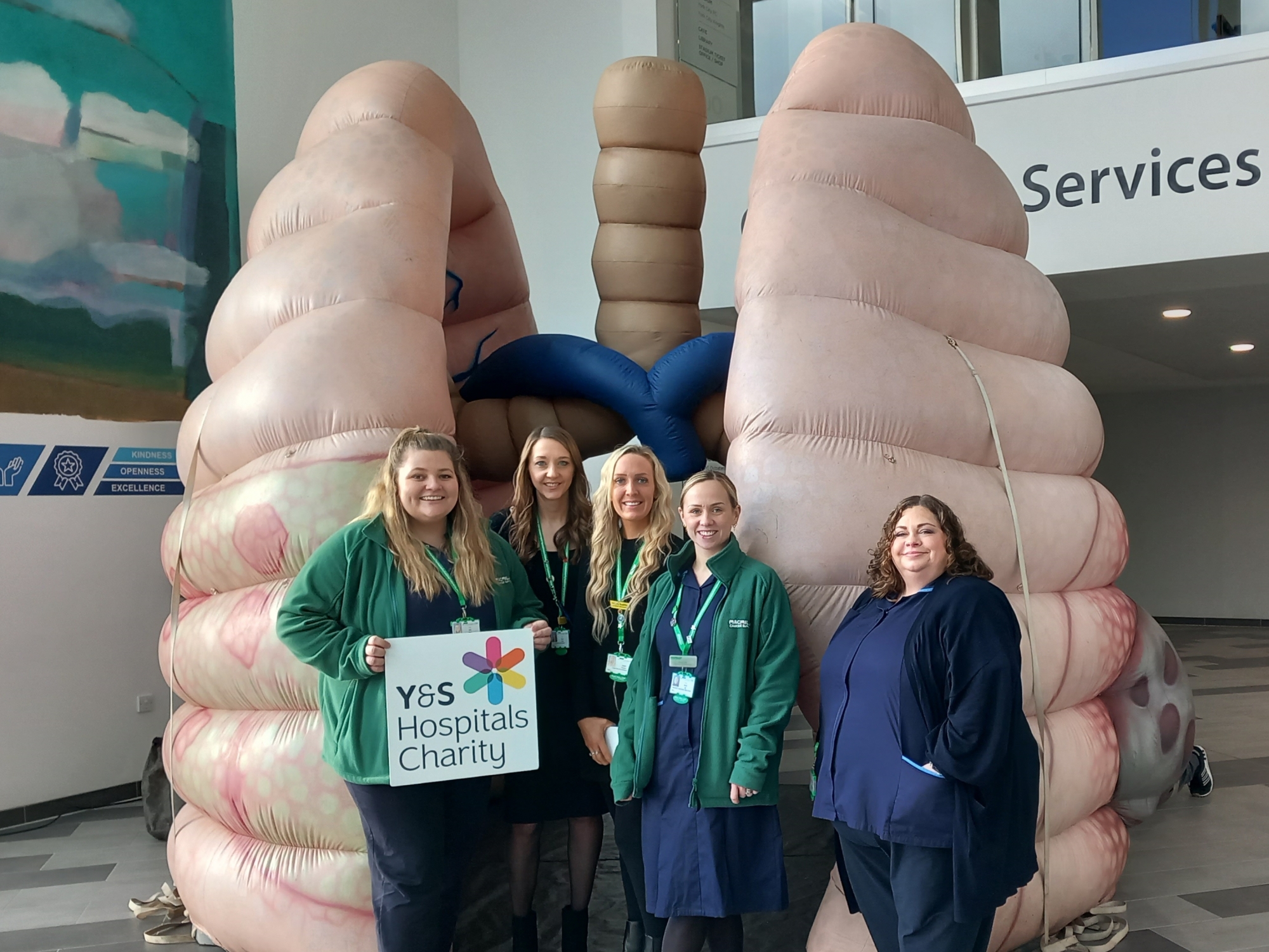 Lung Cancer Nurse Specialists from our hospitals standing in front of a 12ft pair of inflatable lungs.