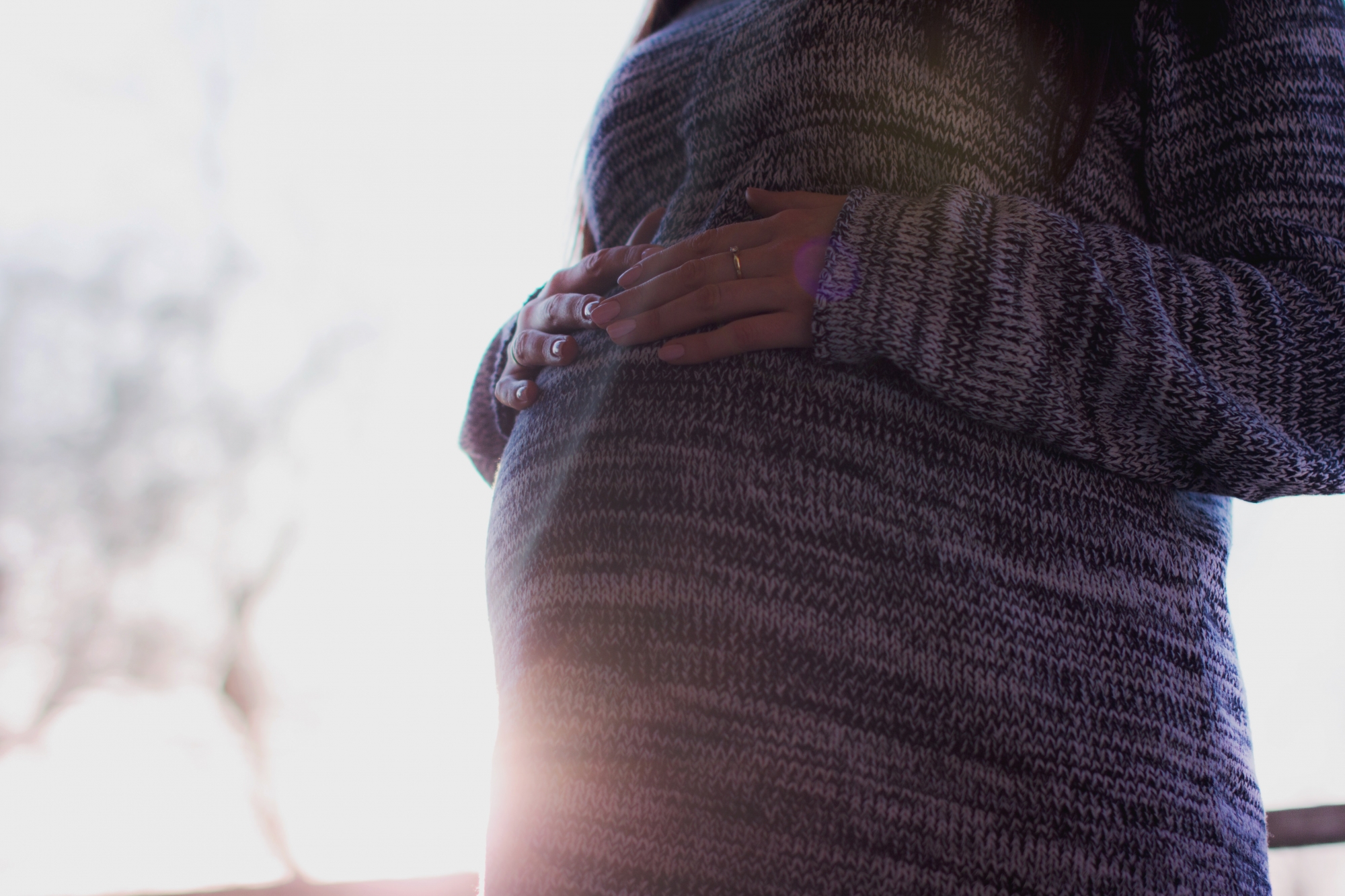 A pregnant woman on a sunny day.