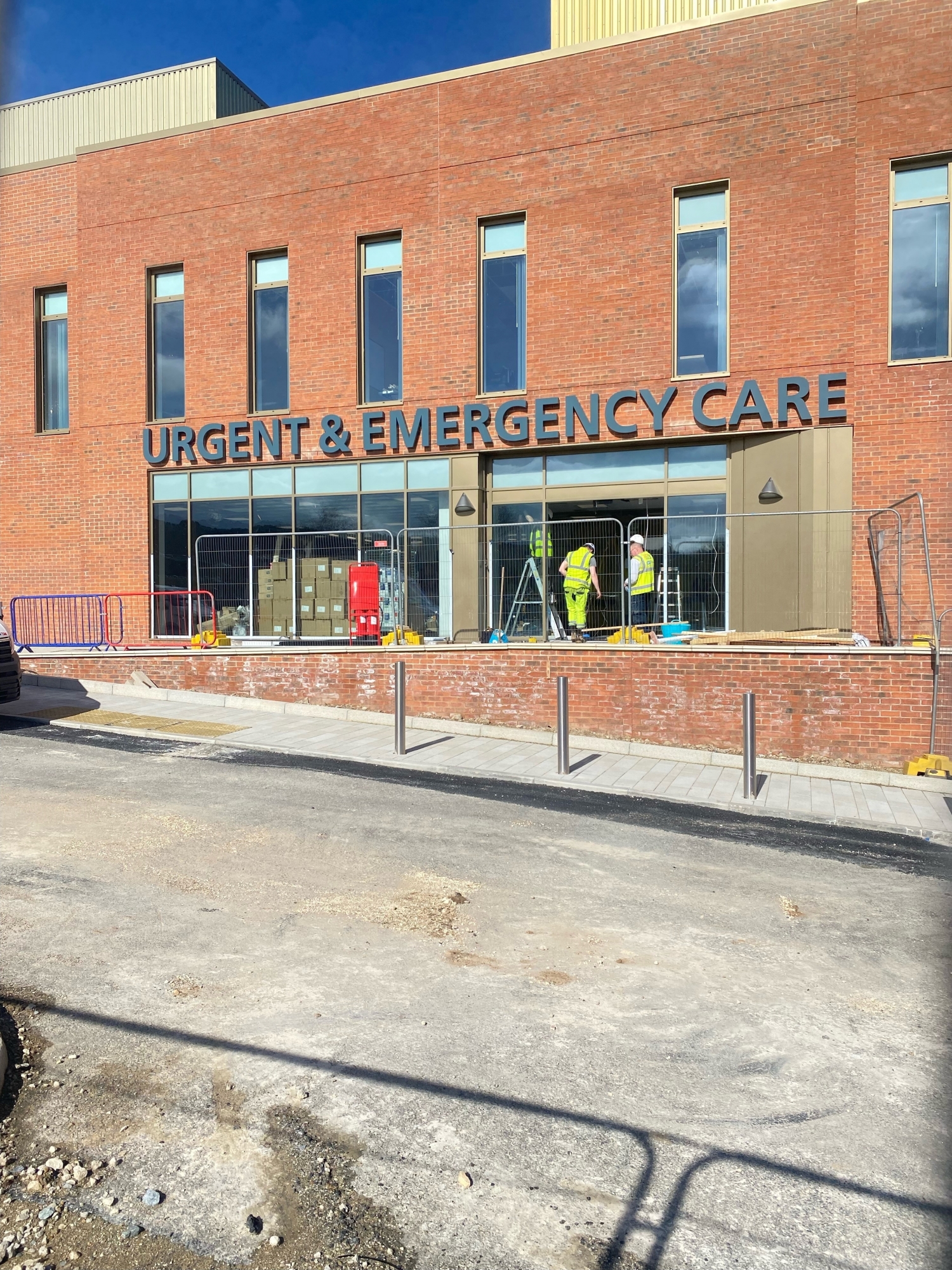 Almost finished urgent and emergency care building. Builders can be seen in the entrance.